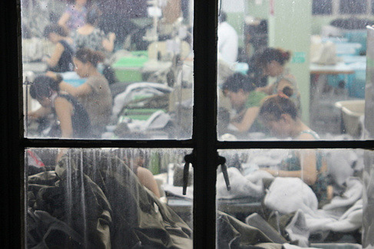 grupo de asiáticos trabajando en un taller de costura