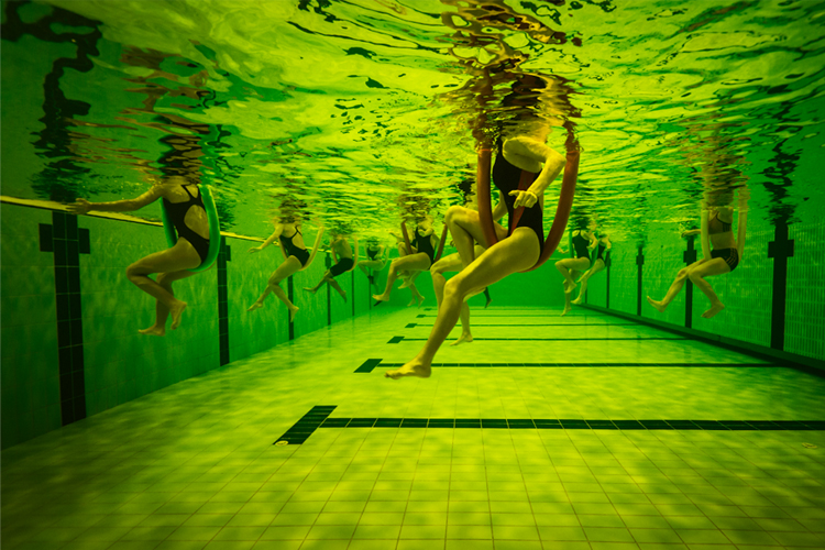 Fotografía de bañistas desde el fondo de una piscina