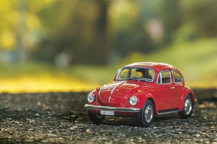 Modelo en miniatura del un coche Volkswagen escarabajo de color rojo.