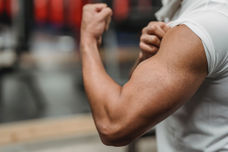 [fotografía] primer plano de un varón marcando bíceps