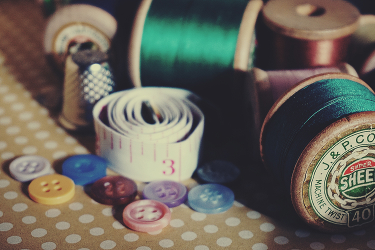 [fotografía] bodegón de artículos para coser: botones, metros y bobinas de hilo