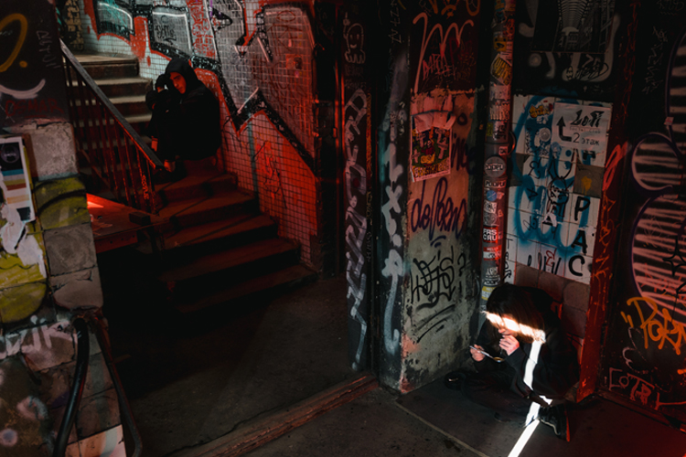 [fotografía] dos drogadictos en un lugar subterráneo decorado profusamente con grafitos