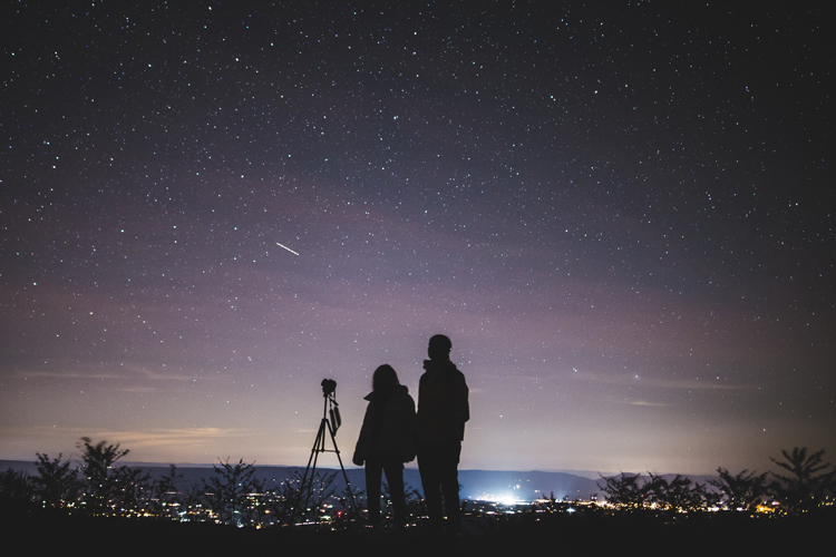 [fotografía] dos personas observando el cielo desde un punto elevado